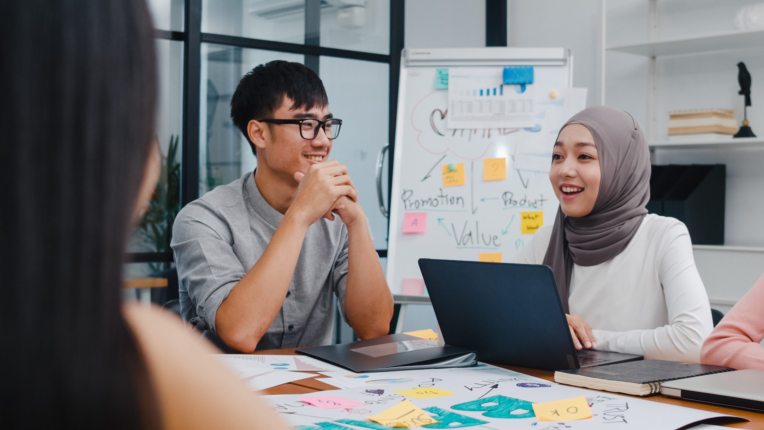 Ilustrasi tim bisnis sedang brainstorming di meja kerja, menempel sticky notes penuh ide di papan tulis